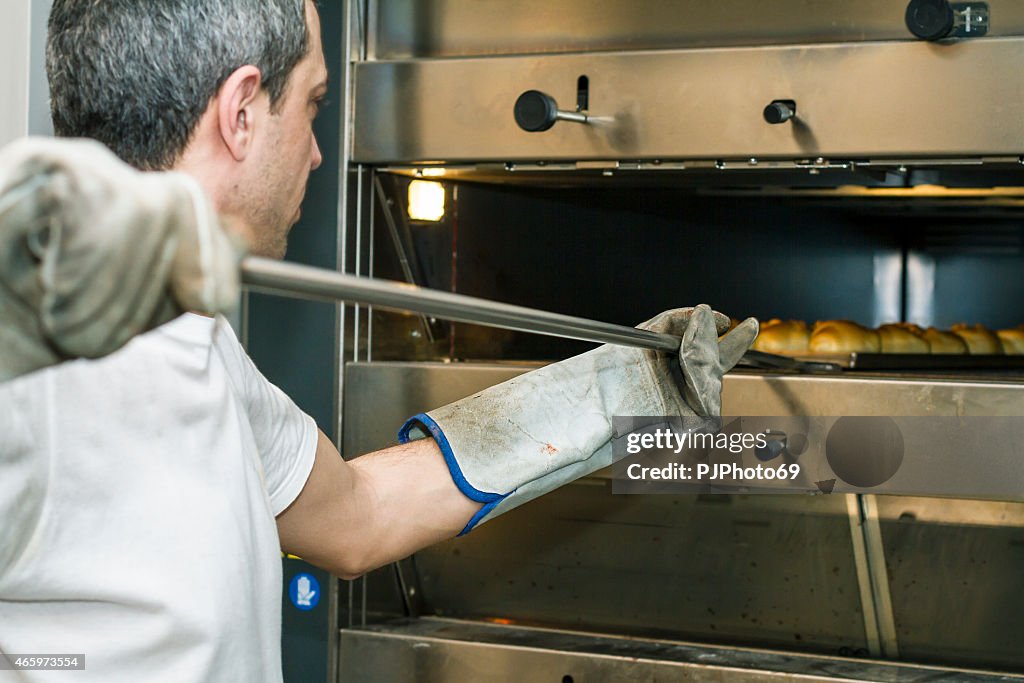 Baker inserting breads in to oven