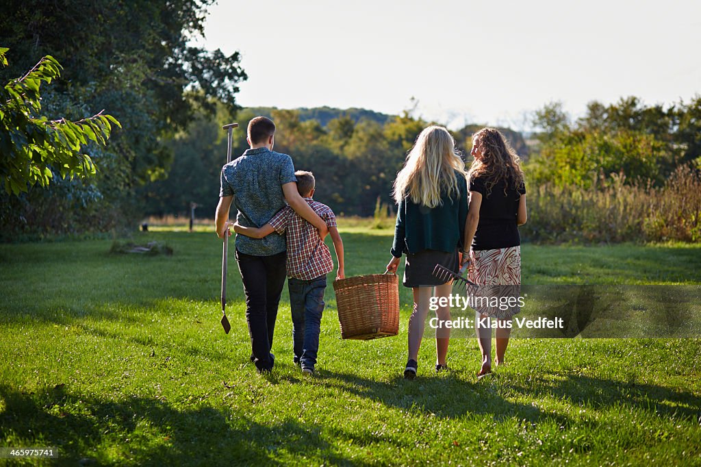 Family walking down green lawn in garden