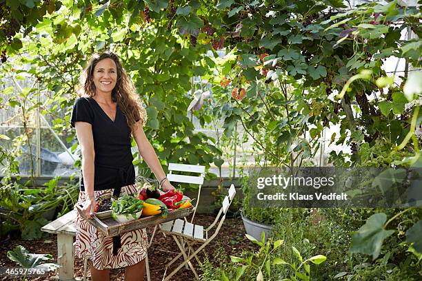 woman standing in greenhouse - vegetable tray stock pictures, royalty-free photos & images