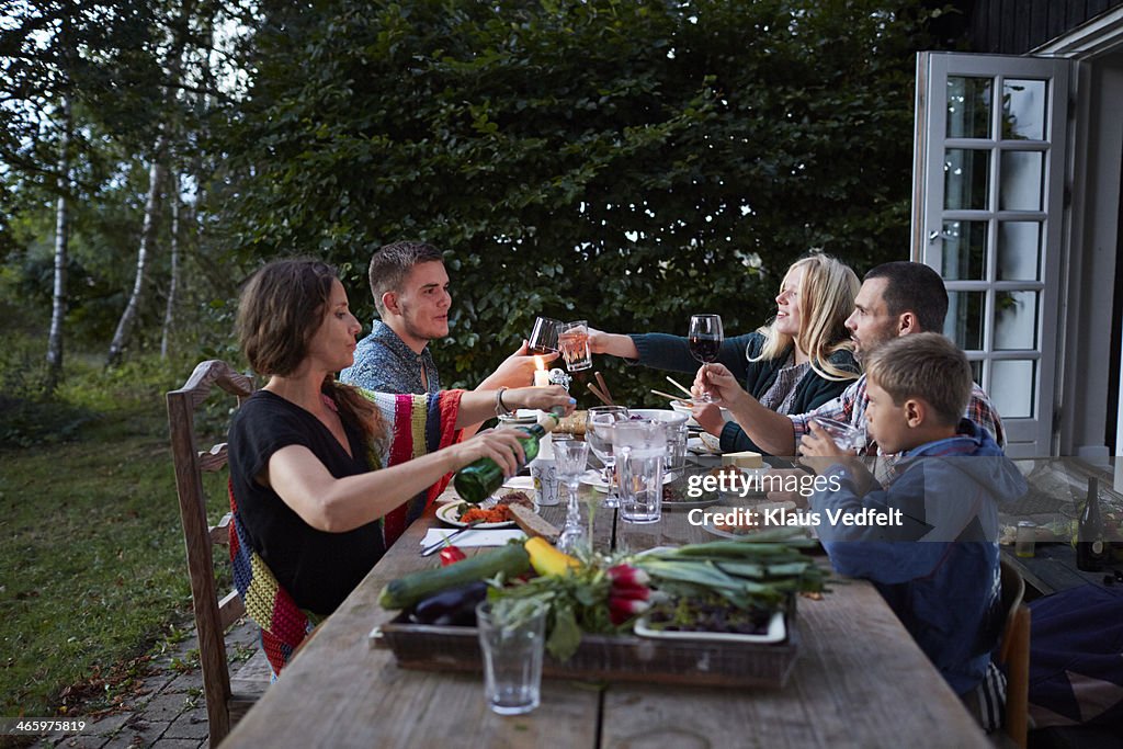 Family toasting at outside dinner table