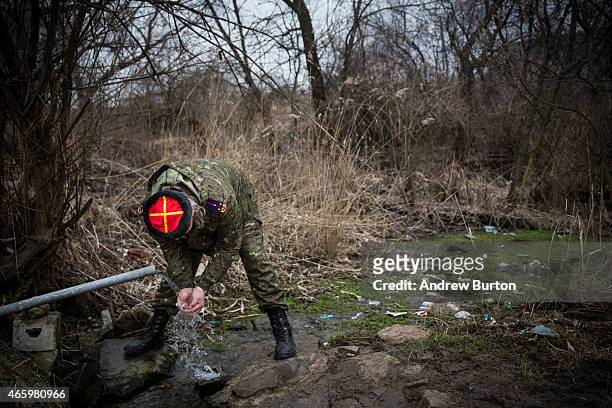 An ethnically Cossack pro-Russian rebel drinks from a spring said to have natural minerals on March 12, 2015 in Makeevka, Ukraine. The conflict...