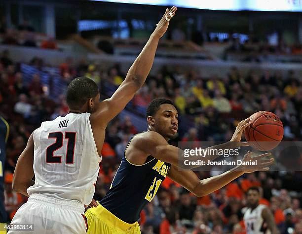 Zak Irvin of the Michigan Wolverines passes under pressure from Malcolm Hill of the Illinois Fighting Illini during the second round of the 2015 Big...