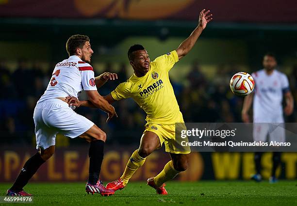 Ikechukwu Uche of Villarreal competes for the ball with Daniel Carrico of Sevilla during the UEFA Europa League round of 16 match between Villarreal...