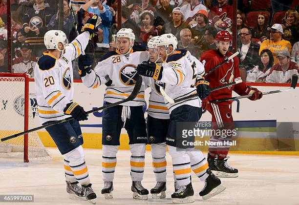 Zemgus Girgensons of the Buffalo Sabres celebrates with teammates Henrik Tallinder, Brian Flynn and Alexander Sulzer following his third period goal...