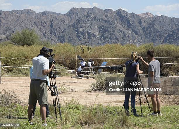 French journalists make images of the experts working with the wreckage of the helicopter at Villa Castelli, in the Argentine province of La Rioja,...