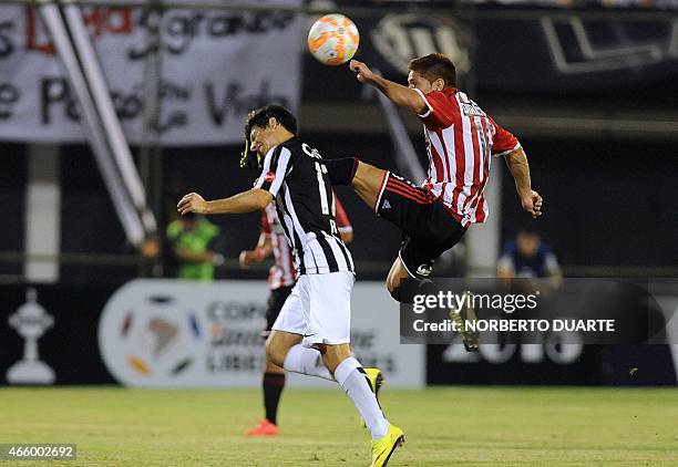 Argentina's Estudiantes de la Plata's Leandro Gil vies for the ball with Oscar Ruiz of Paraguayan Libertad during their Libertadores Cup football...