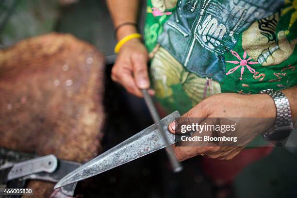 Butcher sharpens a knife before cutting buffalo meat, unseen, at a beef store in New Delhi, India, on Wednesday, March 11, 2015. The government of...
