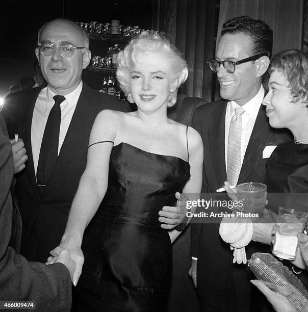 Actress Marilyn Monroe chats with guests at Jackie Gleason's birthday party at Toots Shor's Restaurant on February 26, 1955 in New York City, New...