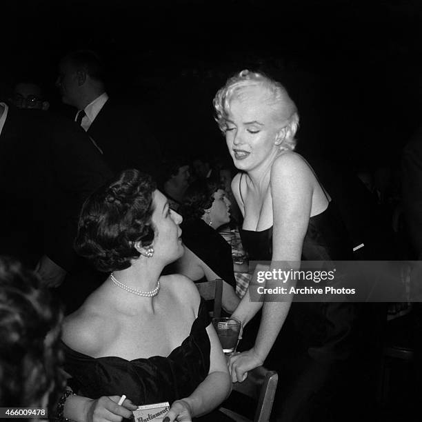 Actress Marilyn Monroe chats with a guest at Jackie Gleason's birthday party at Toots Shor's Restaurant on February 26, 1955 in New York City, New...