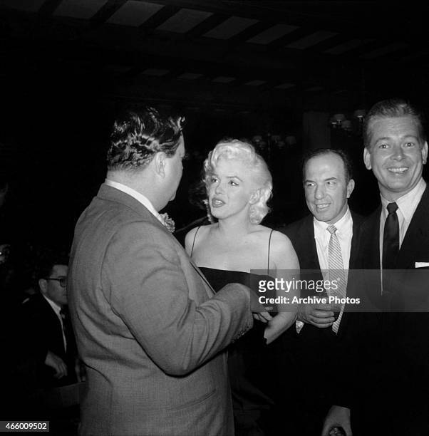 Actress Marilyn Monroe chats with Jackie Gleason at is birthday party at Toots Shor's Restaurant on February 26, 1955 in New York City, New York.