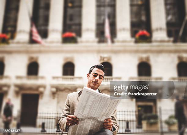 business mann liest zeitung sitzt auf der wall street - paper city stock-fotos und bilder