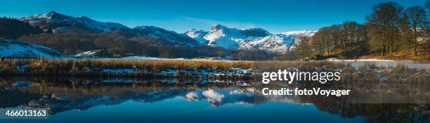 lake district snowy winter mountain peaks reflecting in tarn cumbria - ambleside stock pictures, royalty-free photos & images