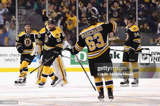 Patrice Bergeron, David Pastrnak and Carl Soderberg congratulate Brad Marchand of the Boston Bruins after he scored the game winning goal during a...