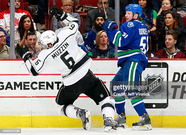 Jake Muzzin of the Los Angeles Kings stumbles after colliding with Derek Dorsett of the Vancouver Canucks during their NHL game at Rogers Arena March...