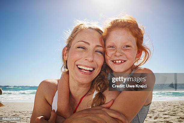 portrait of mother and daughter smiling at beach - female 40 year old beach stock pictures, royalty-free photos & images