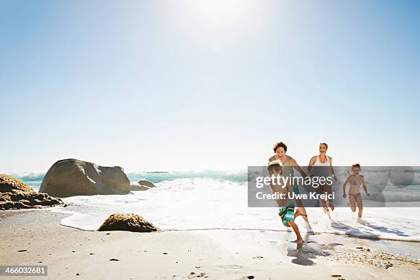 happy family running on the beach - couple running on beach stock pictures, royalty-free photos & images