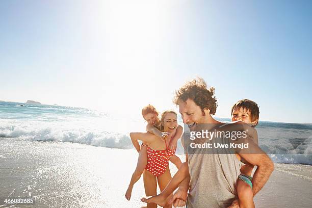 family playing at the beach - spiaggia foto e immagini stock