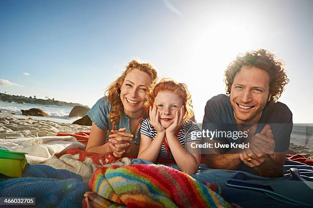 portrait of family at the beach - allongé sur le devant photos et images de collection