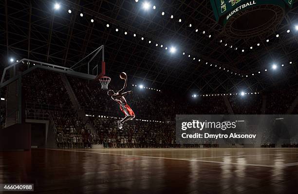 basketball player makes slam dunk - basketball stadium stock pictures, royalty-free photos & images