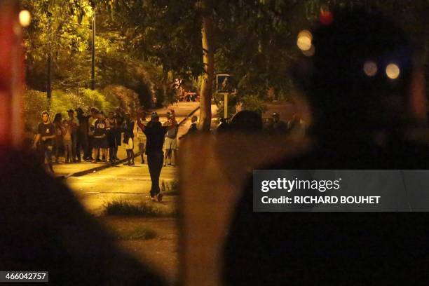 Youths gesture within clashes with riot police on January 30, 2014 in the Chaudron district of Saint-Denis de La Reunion, French Indian Ocean....