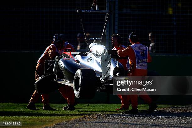 Kevin Magnussen of Denmark and McLaren Honda's car is lifted off the track after he crashed during practice for the Australian Formula One Grand Prix...