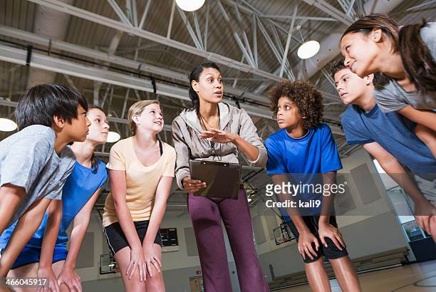 group of children with coach in school gym - gym coach stock pictures, royalty-free photos & images