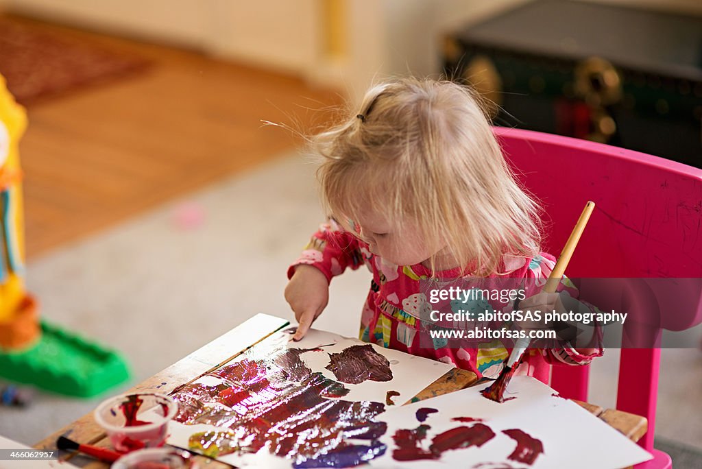 Toddler girl finger painting