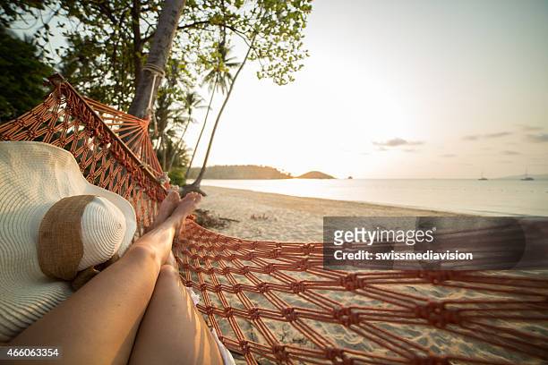 donna di relax su un'amaca sulla spiaggia tropicale - sognare ad occhi aperti foto e immagini stock