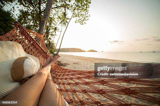 mulher a descansar na cama de rede na praia tropical - hammock imagens e fotografias de stock