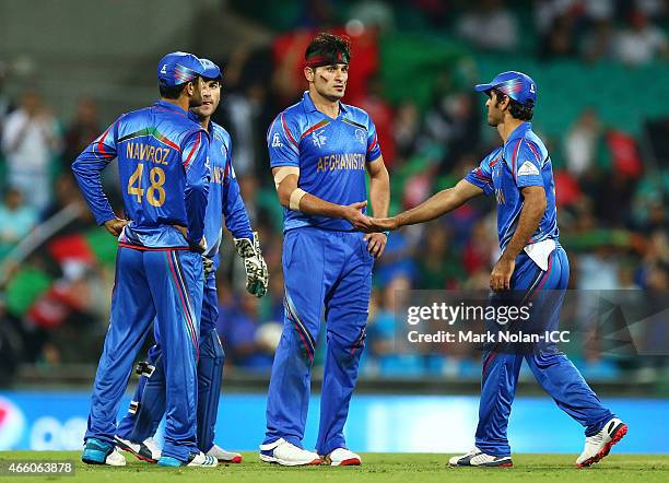 Hamid Hassan of Afghanistan celebrates the wicket of Alex Hales of England with team mates during the 2015 Cricket World Cup match between England...