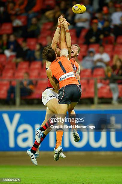 Aidan Corr and Phil Davis of the Giants contest a high ball with Jonathan Giles of the Bombers during the NAB Challenge AFL match between the Greater...