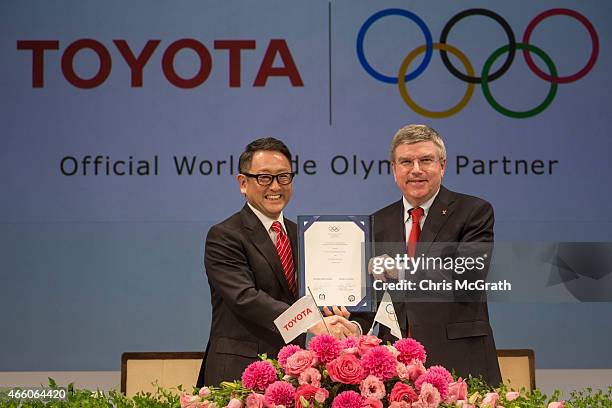 President and CEO of Toyota Motor Corporation, Akio Toyoda and President of the International Olympic Committee Thomas Bach pose for photographers...