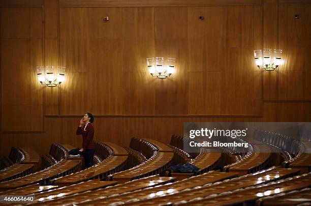 Hostess stands between rows of seats following the concluding session of the Chinese People's Political Consultative Conference at the Great Hall of...