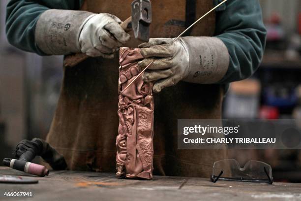 Denis Cahard, an employee at the Bocquel foundry, works on a Cesar Award statuette, the national film award of France, on January 27, 2013 in...