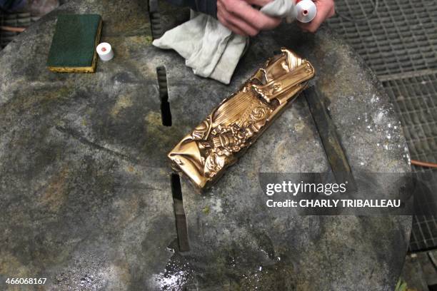 Herve Deschamps, an employee at the Bocquel foundry, works on a Cesar Award statuette, the national film award of France, on January 27, 2013 in...