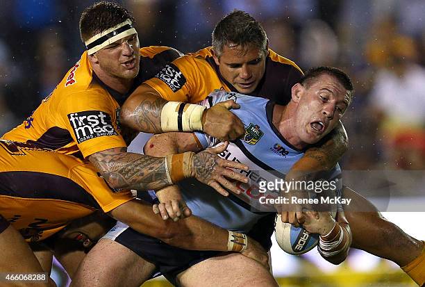 Paul Gallen of the Sharks is tackled by Josh McGuire and Corey Parker of the Broncos during the round two NRL match between the Cronulla Sharks and...