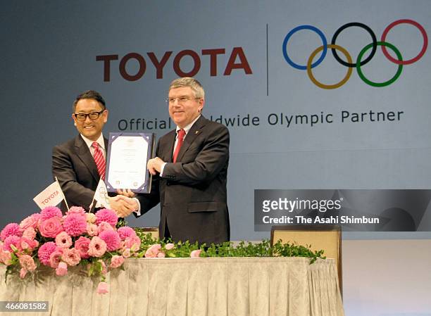 President and CEO of Toyota Motor Corporation, Akio Toyoda and President of the International Olympic Committee Thomas Bach pose for photographers...