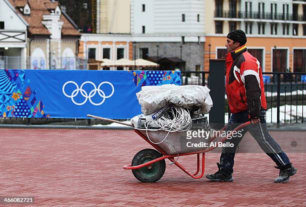 Worker carries supplies to a construction site in the Rosa Khutor Mountain Cluster village ahead of the Sochi 2014 Winter Olympics on January 31,...