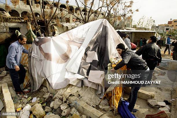 Palestinian refugees, who fled the Yarmuk refugee camp in Syria where they were previously residing due to the ongoing conflict, dismantle their...