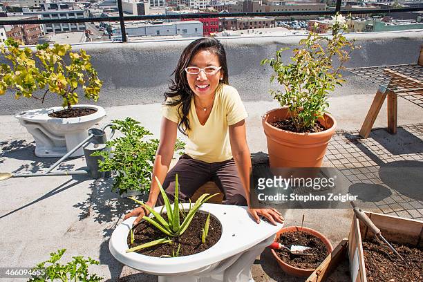 Asian woman using old toilets as planters
