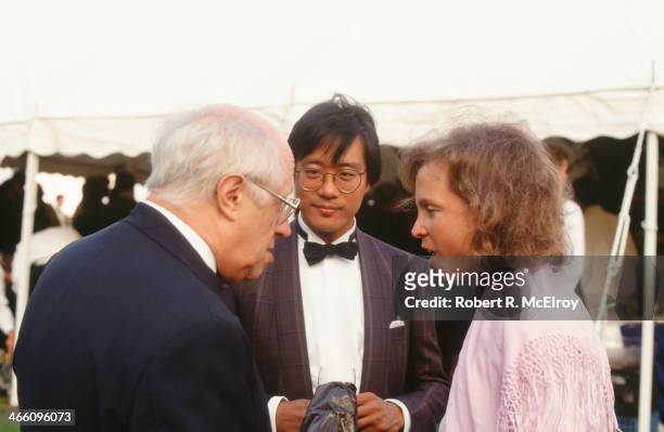 As American cellist Yo-Yo Ma watches, Russian cellist Mstislav Rostropovich speaks with an unidentified woman at an outdoor event, August 25, 1988.