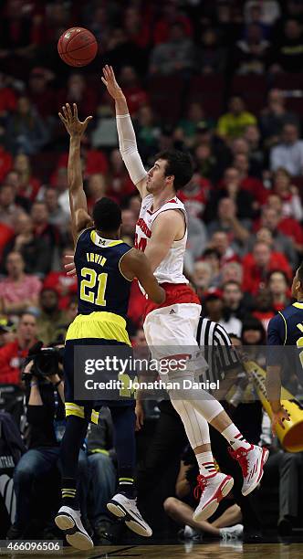 Frank Kaminsky of the Wisconsin Badgers shoots over Zak Irvin of the Michigan Wolverines during the quarterfinal round of the 2015 Big Ten Men's...