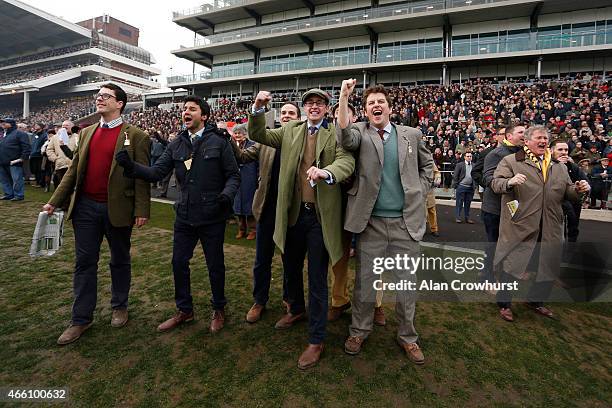 Racegoers cheer home a winner during Gold Cup day at the Cheltenham Festival at Cheltenham racecourse on March 13, 2015 in Cheltenham, England.