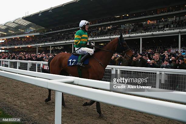 Tony McCoy passes in front of the grandstand on Ned Buntline after finishing his last race at Cheltenham in the A.P. McCoy Grand Annual Handicap...