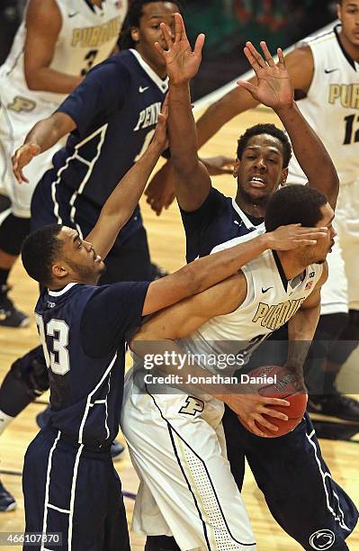 Hammons of the Purdue Boilermakers is trapped by Shep Garner and Jordan Dickerson of the Penn State Nittany Lions during the quarterfinal round of...