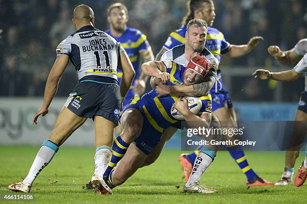 Chris Hill of Warrington Wolves is tackled by Jamie Peacock of Leeds Rhinos during the First Utility Super League match between Warrington Wolves and...