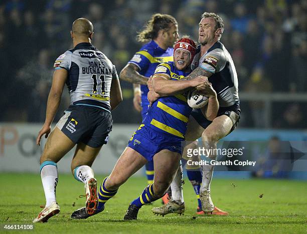 Chris Hill of Warrington Wolves is tackled by Jamie Peacock of Leeds Rhinos during the First Utility Super League match between Warrington Wolves and...