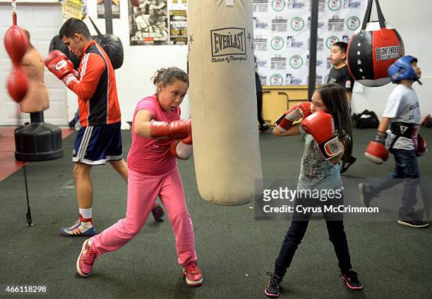 Surrounded by young boxers, Golden Gloves boxer Julio Para, left, works the double end bag as he trains at the Colorado Golden Gloves Gym in Wheat...