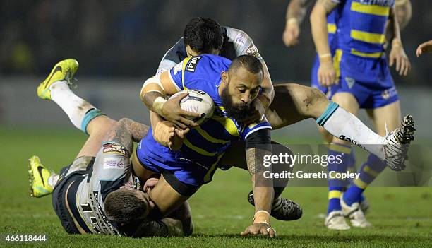 Roy Asotasi of Warrington Wolves is tackled by Brett Delaney and Kylie Leuluai of Leeds Rhinos during the First Utility Super League match between...