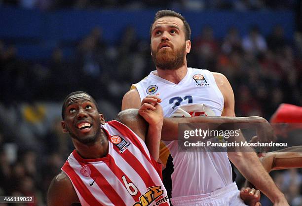 Oguz Savas, #21 of Fenerbahce Ulker Istanbul competes with Bryant Dunston, #6 of Olympiacos Piraeus during the Turkish Airlines Euroleague Basketball...